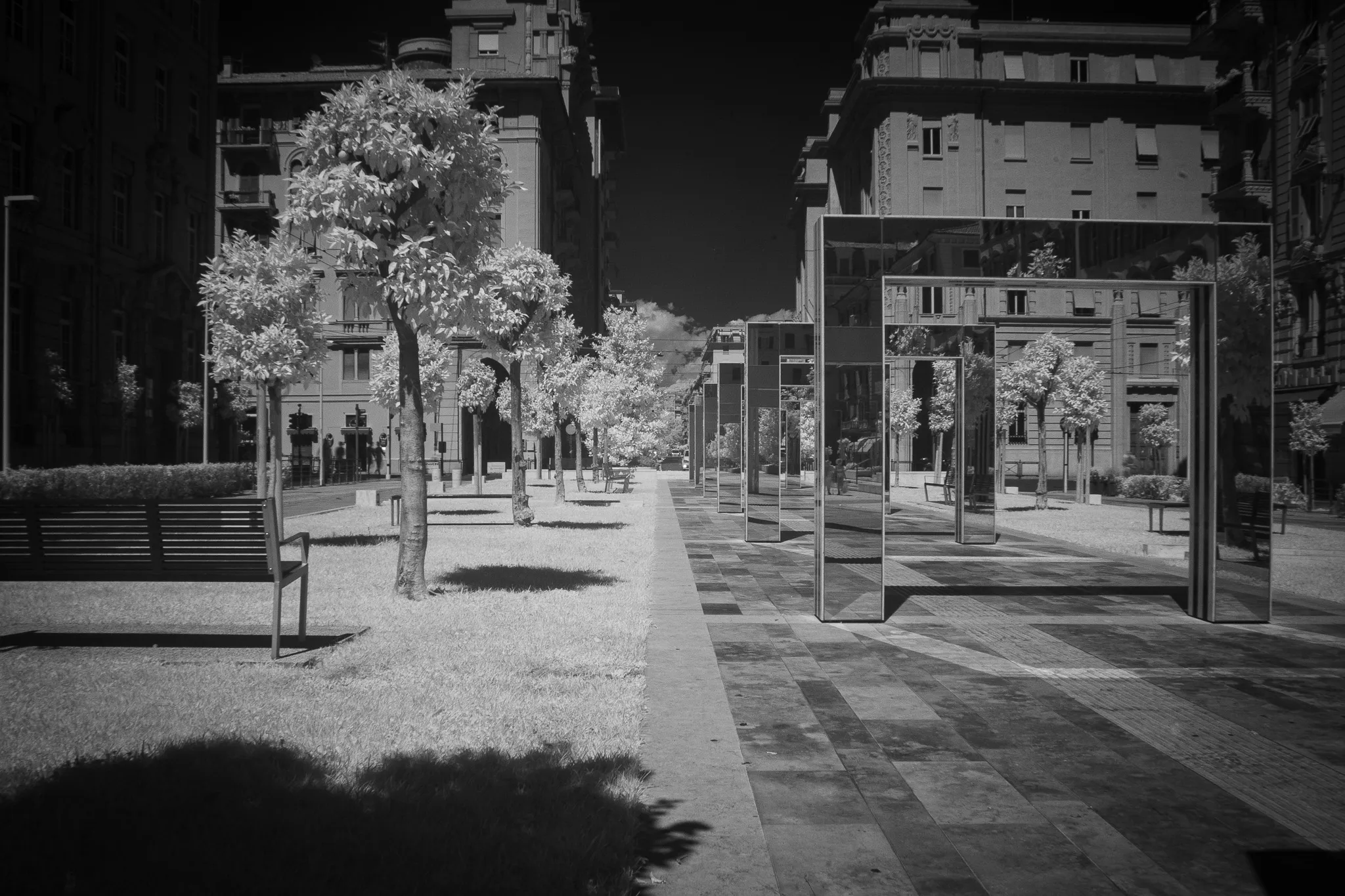 Viale pedonale alberato tra i palazzi, con strutture in vetro, in infrarosso